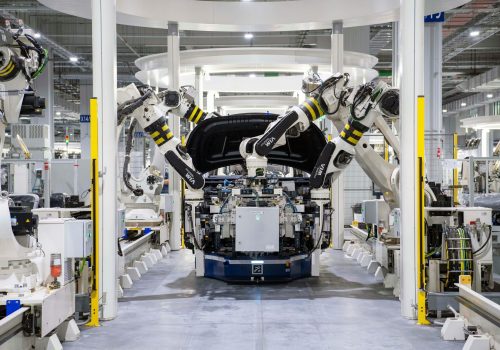 High-tech robots assembling a car in a modern factory setting, showcasing automation.
